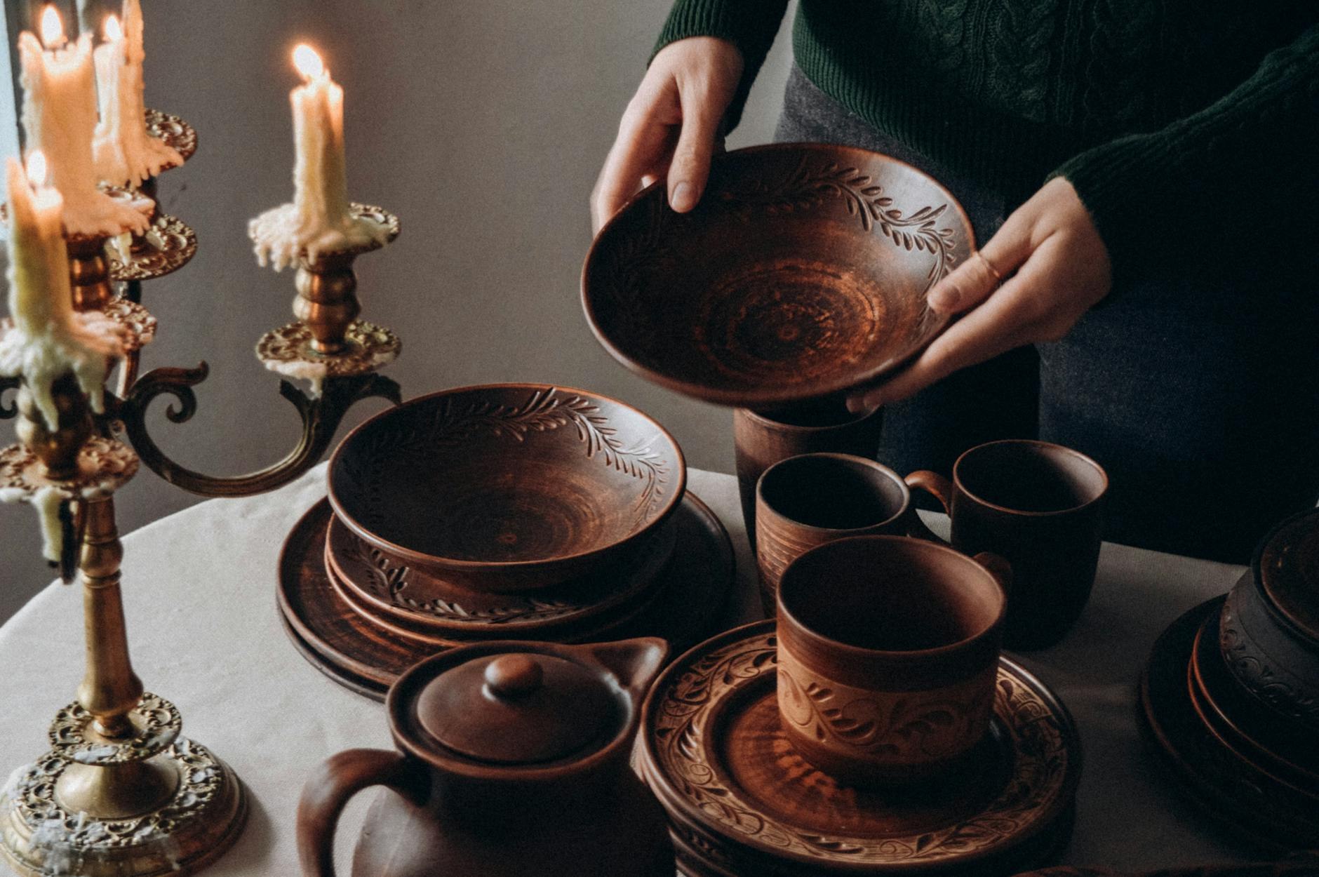 Ceramic plates and hands arranging tableware in natural light